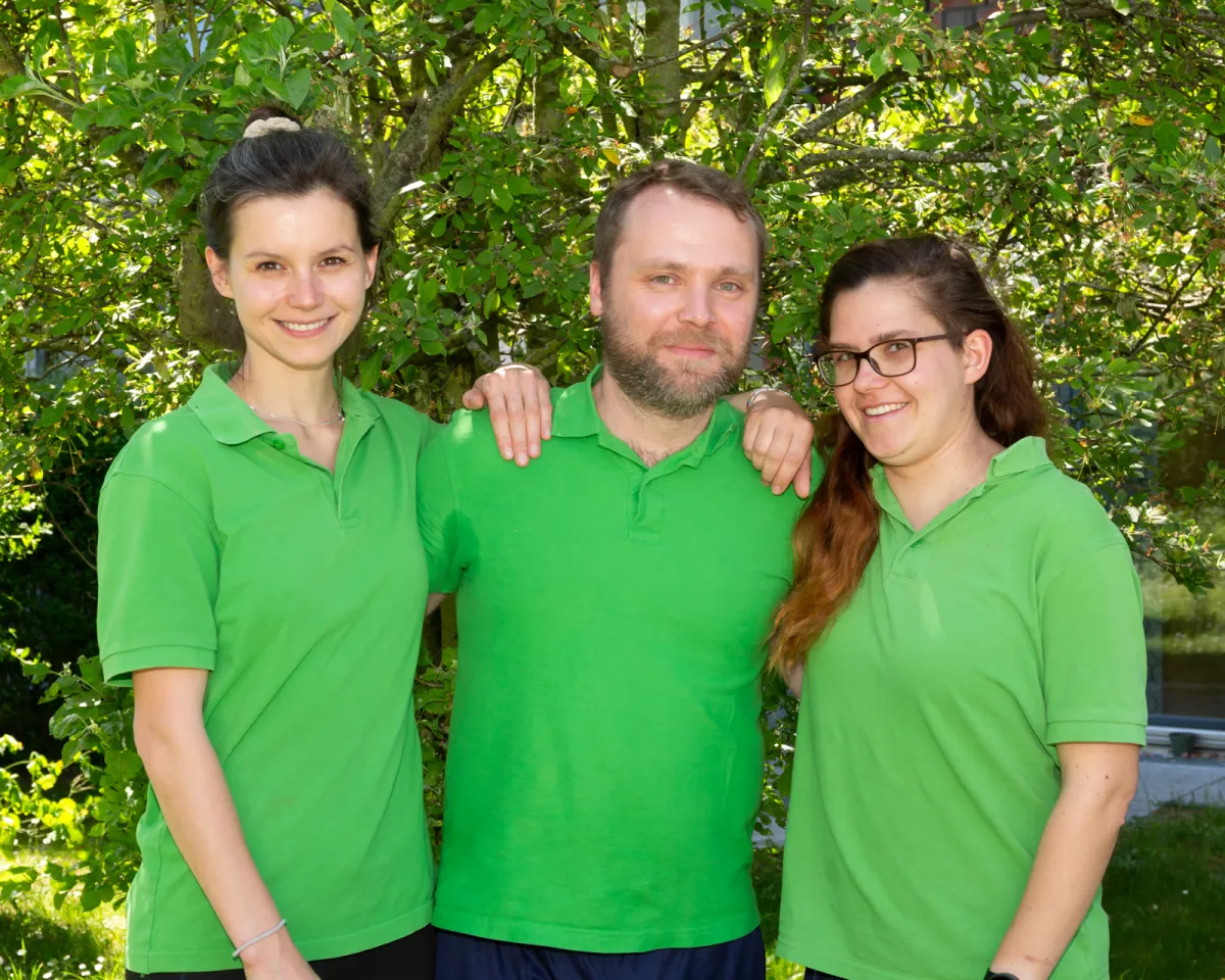 Drei Therapeutinnen und Therapeuten des Physiopark im Garten